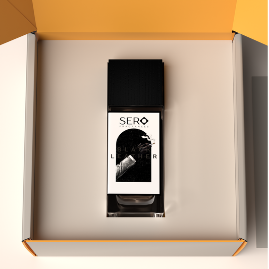 Top view of a packaging within it a minimalist clear glass perfume bottle with black wood cap containing SERO fragrance inspired by TOM FORD's Ombré Leather.