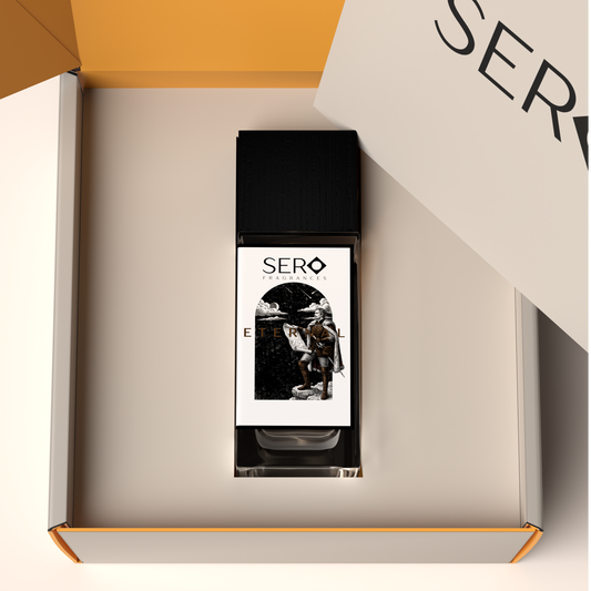 Top view of a packaging within it a minimalist clear glass perfume bottle with black wood cap containing SERO fragrance inspired byPenhaligon's Halfeti Leather.