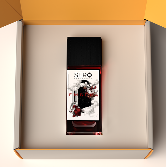 Top view of a packaging within it a minimalist clear glass perfume bottle with black wood cap containing SERO fragrance inspired by Baccarat Rouge. 
