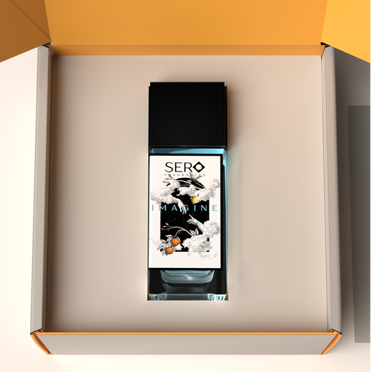 Top view of a packaging within it a minimalist clear glass perfume bottle with black wood cap containing SERO fragrance inspired by LV Imagination. 
